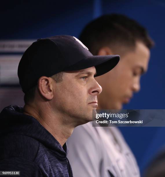 Manager Aaron Boone of the New York Yankees looks on from the dugout as Giancarlo Stanton gets ready to bat during MLB game action against the...