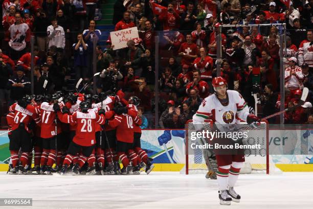 Sergei Kostitsyn of Belarus reacts as the Swiss team celebrate their win during the ice hockey Men's Qualification Playoff game between Switzerland...