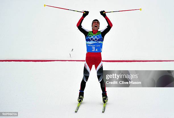 Mario Stecher of Austria celebrates after crossing the finish line to win the gold medal for his team during the nordic combined on day twelve of the...