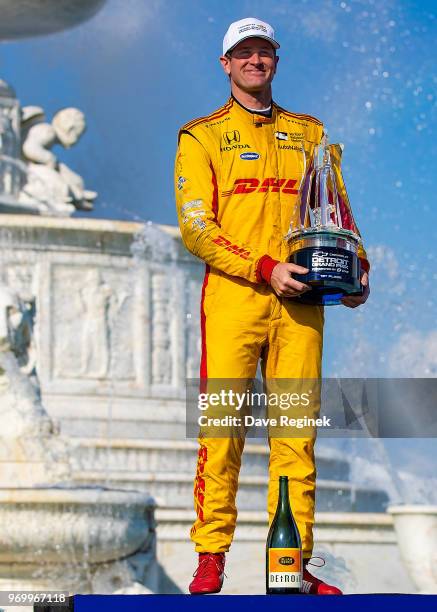 Ryan Hunter-Reay, driver of the Honda Indy Car for Andretti Autosport, poses for pictures with his first place trophy after winning the Chevrolet...