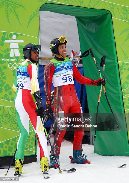 Leyti Seck of Senegal and Samir Azzimani of Morocco stand together at the finish line during the Alpine Skiing Men's Giant Slalom on day 12 of the...