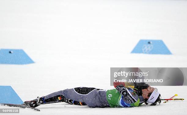 Germany's Tino Edelmann lies in the snow after competing in his leg of the men's Nordic Combined team 4x5 km at the Whistler Olympic Park during the...