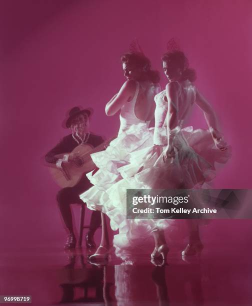 Flamenco Dancer with guitar player perform El baile flamenco against a red background in circa 1983.