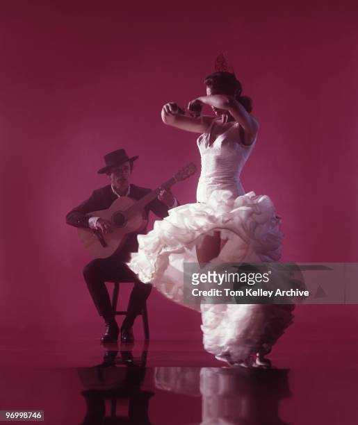 Flamenco Dancer with guitar player perform El baile flamenco against a red background in circa 1983.
