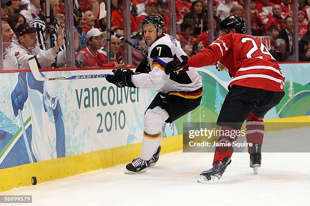 Corey Perry of Canada fights for the puck against Christopher Schmidt of Germany during the ice hockey Men's Qualification Playoff game between...