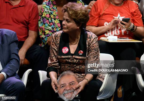 Brazilian former president Dilma Roussef, holds a mask depicting Brazilian jailed ex-president , Luiz Inacio Lula da Silva, during the launching of...