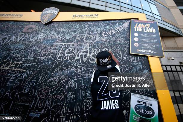 Jojo Jacobs signs a chalkboard outside the arena before Game Four of the 2018 NBA Finals between the Cleveland Cavaliers and the Golden State...