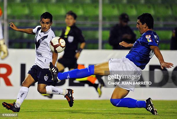 Venezuelan Deportivo Italia's player Javier Lopez vies for the ball with Maximiliano Morales of Argentinian Velez Sarsfield during their Copa...