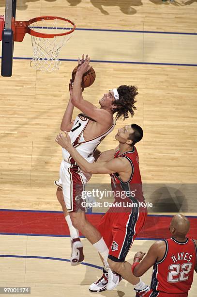 Anderson Varejao of the Cleveland Cavaliers goes up for a shot against Yi Jianlian and Jarvis Hayes of the New Jersey Nets during the game at Quicken...