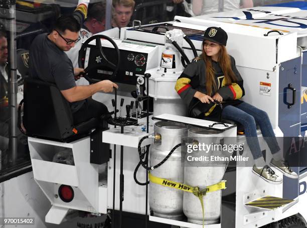 Richard Crossley operates an ice resurfacer while giving a ride to Vegas Golden Knights fan Logan Sokoloski dubbed "The Girl with the Hat" by Golden...