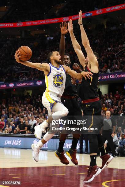 Stephen Curry of the Golden State Warriors drive to the basket against Jeff Green and Larry Nance Jr. #22 of the Cleveland Cavaliers in the first...