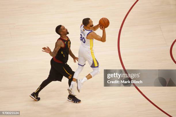 Stephen Curry of the Golden State Warriors shoots a three point basket while guarded by JR Smith of the Cleveland Cavaliers in Game Four of the 2018...
