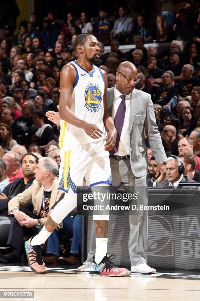 Kevin Durant and Assistant Coach Mike Brown of the Golden State Warriors high five during the game against the Cleveland Cavaliers during Game Four...