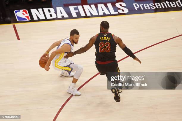 Stephen Curry of the Golden State Warriors dribbles the ball around LeBron James of the Cleveland Cavaliers in Game Four of the 2018 NBA Finals on...