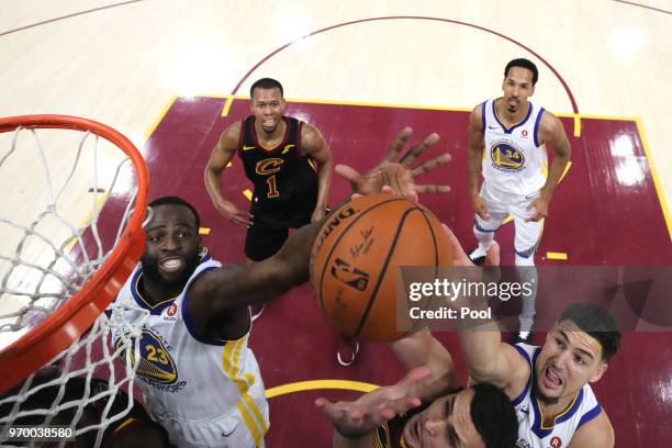 Larry Nance Jr. #22 of the Cleveland Cavaliers competes for the ball with Draymond Green and Klay Thompson of the Golden State Warriors in the first...