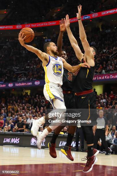 Stephen Curry of the Golden State Warriors attempts a layup over Jeff Green and Larry Nance Jr. #22 of the Cleveland Cavaliers in the first half...