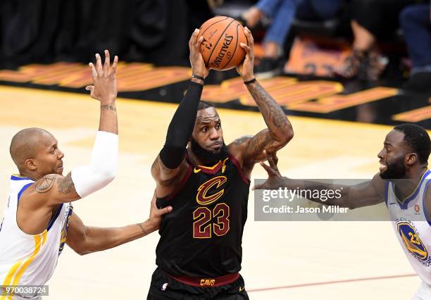 LeBron James of the Cleveland Cavaliers drives to the basket against David West and Draymond Green of the Golden State Warriors in the first half...