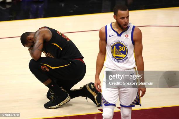 LeBron James of the Cleveland Cavaliers reacts as Stephen Curry of the Golden State Warriors looks on in the first half during Game Four of the 2018...