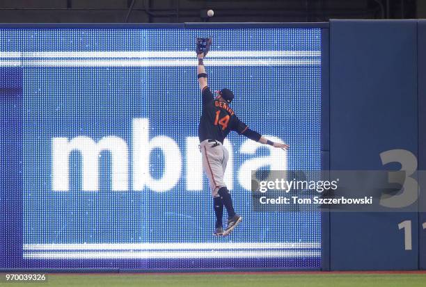 Craig Gentry of the Baltimore Orioles leaps but cannot catch an RBI triple by Teoscar Hernandez of the Toronto Blue Jays in the seventh inning during...