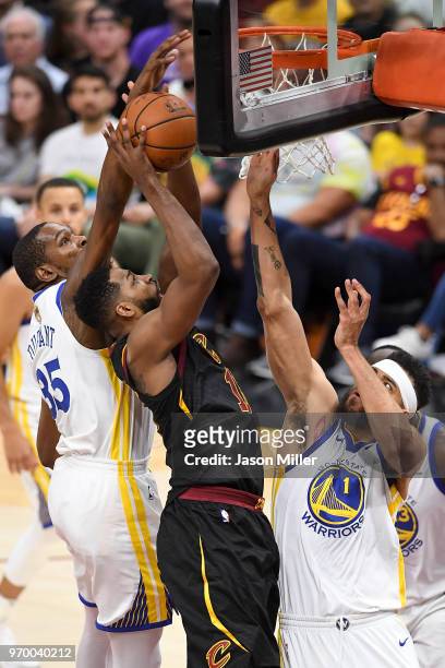 Kevin Durant and JaVale McGee of the Golden State Warriors defend a shot by Tristan Thompson of the Cleveland Cavaliers in the first half during Game...