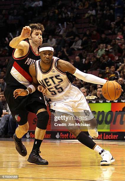 Keyon Dooling of the New Jersey Nets drives past Rudy Fernandez of the Portland Trail Blazers at the Izod Center on February 23, 2010 in East...