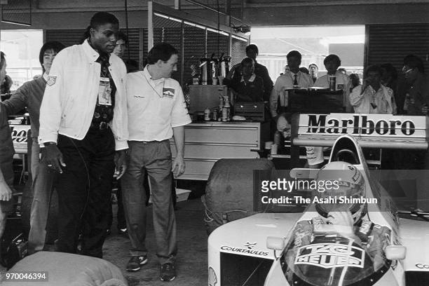 Sprinter Carl Lewis visits the paddock where Ayrton Senna of Brazil and McLaren-Honda prepares prior to the race of the Formula One Japanese Grand...