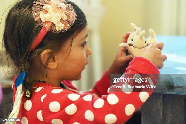 girl of four playing with three stuffed bunnies - adorable bunnies stock-fotos und bilder