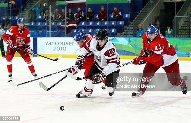 Mikelis Redlihs of Latvia is closed down by Tomas Fleischmann and Miroslav Blatak of Czech Republic during the ice hockey Men's Play-off...