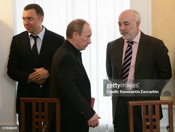 Russian Prime Minister Vladimir Putin arrives as Russian businessman Oleg Deripaska and finance minister Viktor Vekselberg look on as they visits...