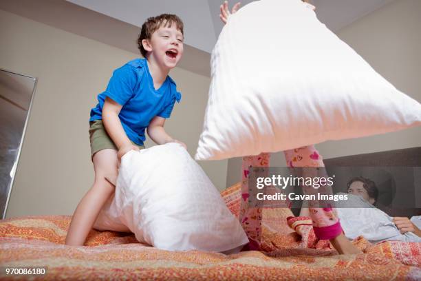low angle view of kids playing pillow fight - pillow fight fotografías e imágenes de stock