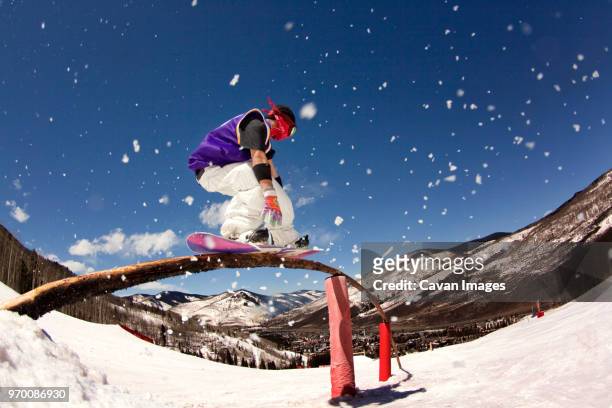 man skateboarding on railing at snow covered field - denver winter stock pictures, royalty-free photos & images