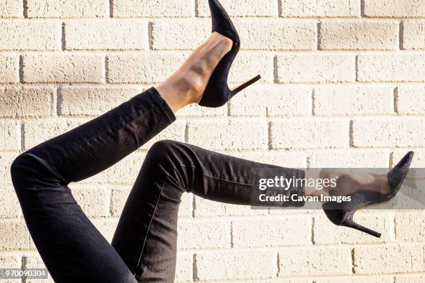 cropped image of womans legs against wall - black shoe stock pictures, royalty-free photos & images