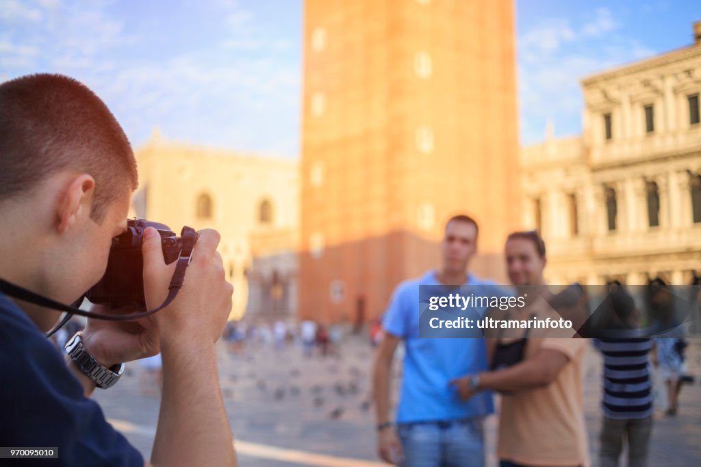 Tourists in Venezia. Three young men, have fun. Group of friends taking a  photo, St Mark's Cathedral in Piazza San Marco, Venice. Casual lifestyles Urban scene Italy.  Visiting Venice, Italy.