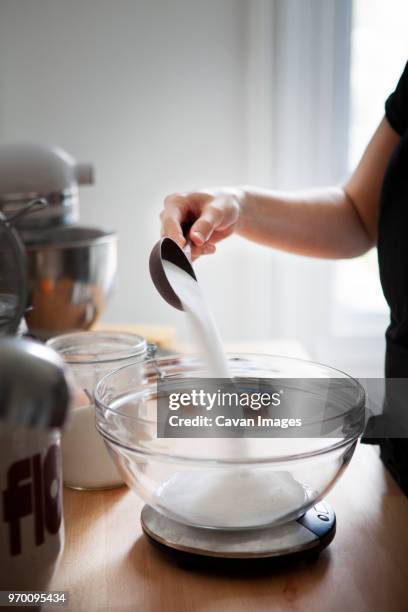 cropped image of woman pouring flour in bowl kept on kitchen scale - köksvåg bildbanksfoton och bilder