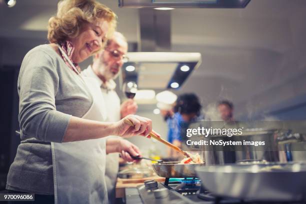 people in a cooking class enjoying their time - senior cooking stock pictures, royalty-free photos & images