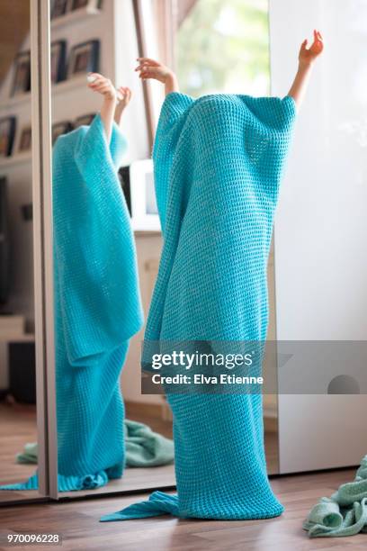 child hiding under a turquoise blanket with only her arms visible - childrens closet stock pictures, royalty-free photos & images