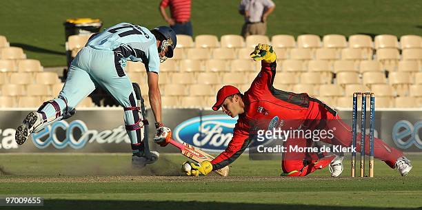 Moises Henriques of the Blues makes his ground in front of a diving Graham Manou of the Redbacks during the Ford Ranger Cup match between the South...