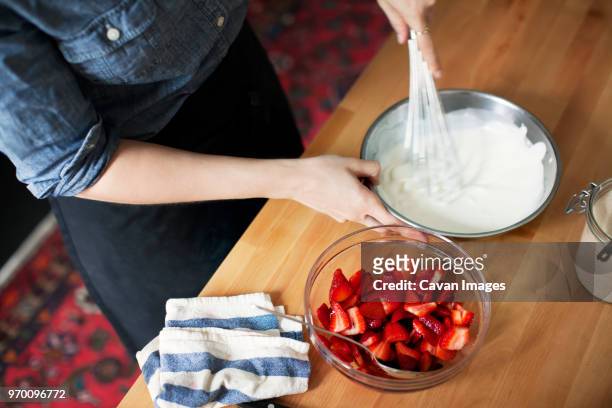 high angle view of woman preparing whipped cream - strawberry and cream stock pictures, royalty-free photos & images