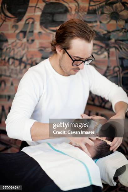 barber shaving man in hair salon - sud side company stock pictures, royalty-free photos & images