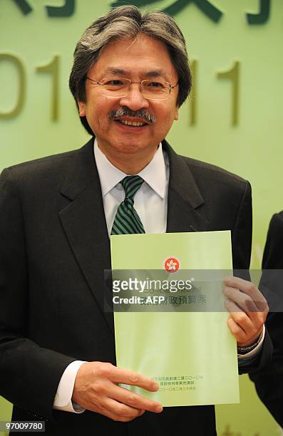 Hong Kong Financial Secretary John Tsang holds a copy of the budget prior to a media briefing in Hong Kong on February 24, 2010. Hong Kong said that...