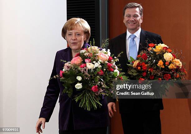 German Chancellor Angela Merkel and Vice Chancellor and Foreign Minister Guido Westerwelle arrive with flowers at the weekly German government...