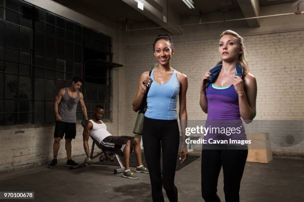 woman standing while man exercising in gym - black woman gym clothing stock pictures, royalty-free photos & images