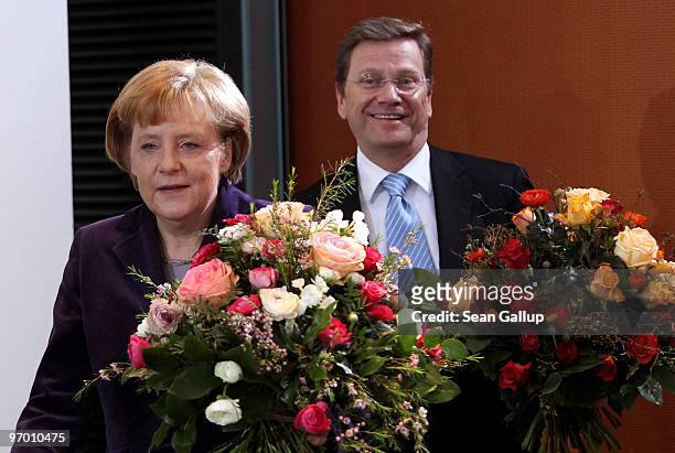 German Chancellor Angela Merkel and Vice Chancellor and Foreign Minister Guido Westerwelle arrive with flowers at the weekly German government...