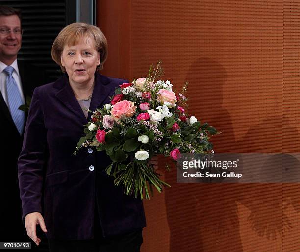 German Chancellor Angela Merkel and Vice Chancellor and Foreign Minister Guido Westerwelle arrive with flowers at the weekly German government...