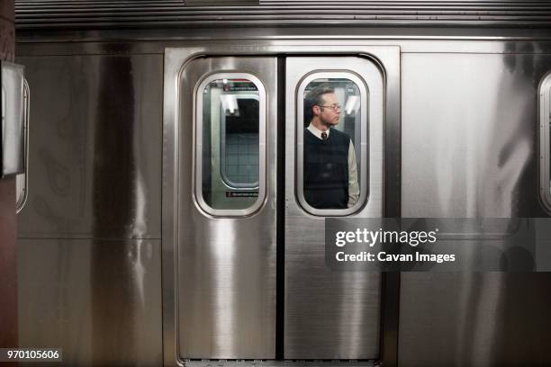 businessman seen through train door - 地下鉄電車 ストックフォトと画像