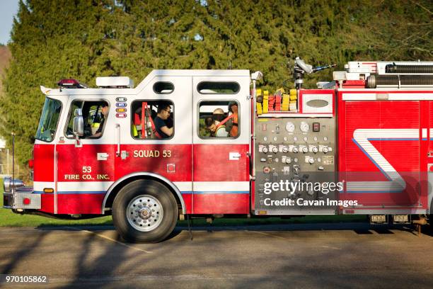 fire fighters sitting in fire engine - fire engine ストックフォトと画像