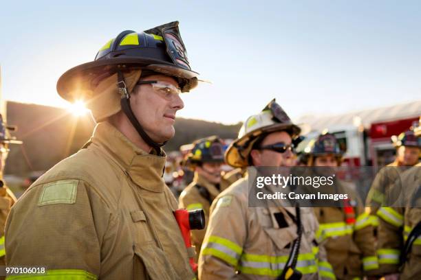 firefighters standing at fire station - salva-vidas-serviço-de-emergência-e-resgate - fotografias e filmes do acervo