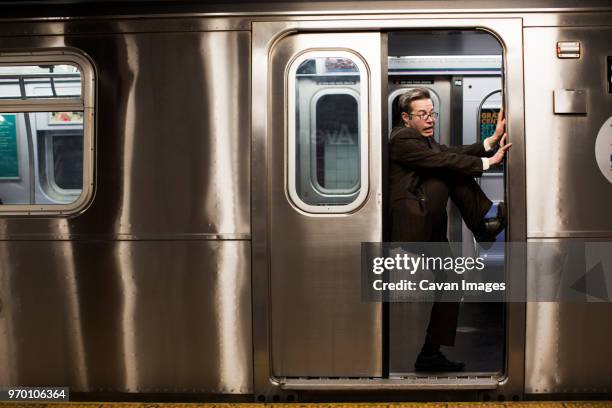 businessman stuck in train door - bloccato foto e immagini stock