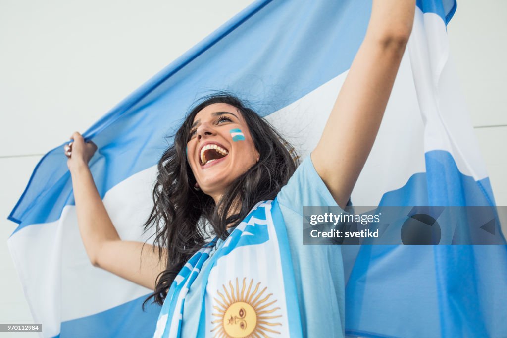 Soccer fan cheering for national team at the game