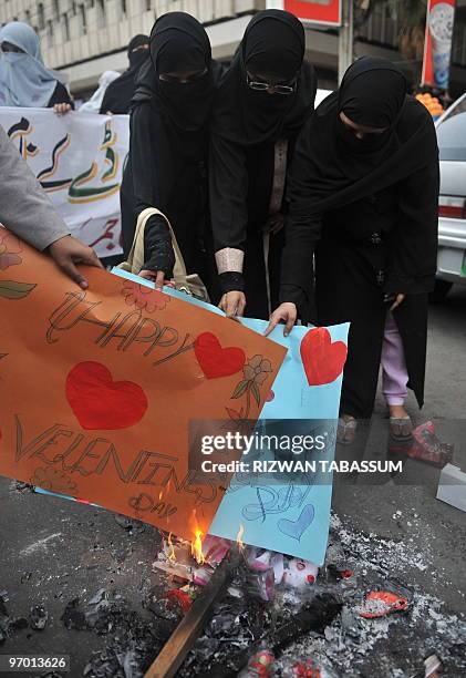 Pakistani activists of Sunni Muslim group Jamaat-e-Ahle Sunnat burn Valentine's greeting cards during a demonstration against Valentine's Day...